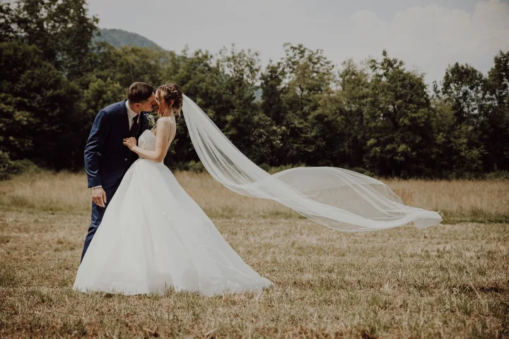 Coppia di sposi che si bacia in un prato a Caraglio, Cuneo. Matrimonio italiano, fotografo di matrimonio in provincia di Cuneo.